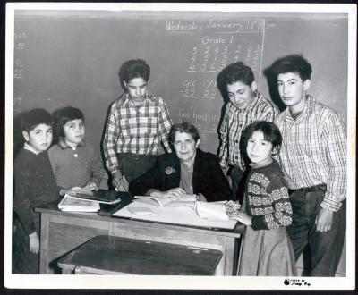 Photograph of a teacher with students in classroom