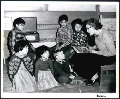 Photograph of a teacher with students in classroom