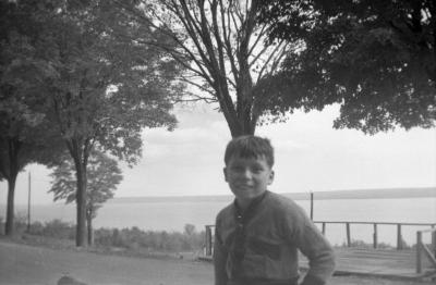 Photograph of a boy in front of a tree