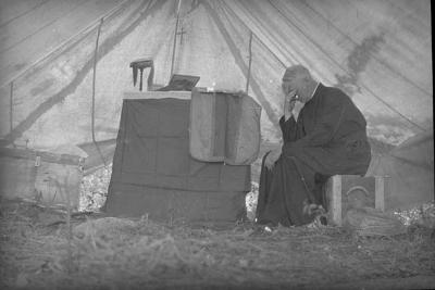 Photograph of a clergyman inside a tent at Fort Albany