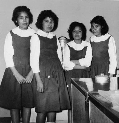Photograph of four senior girls serving refreshments