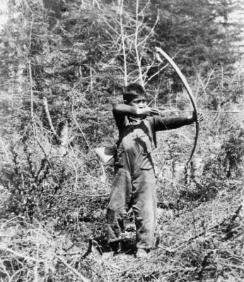 Photograph of a young boy bow hunting