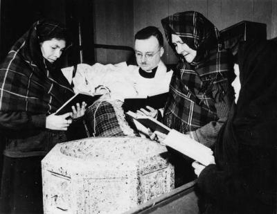 Photograph of Rev. Gilbert Thompson performing a baptism service