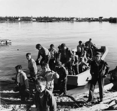 Photograph of students crossing the river for school