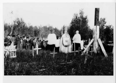 Photograph of clergy members and children in the cemetery at Fort Albany