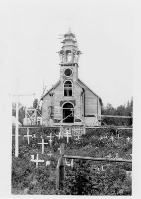 Photograph of a chapel under construction and the cemetery